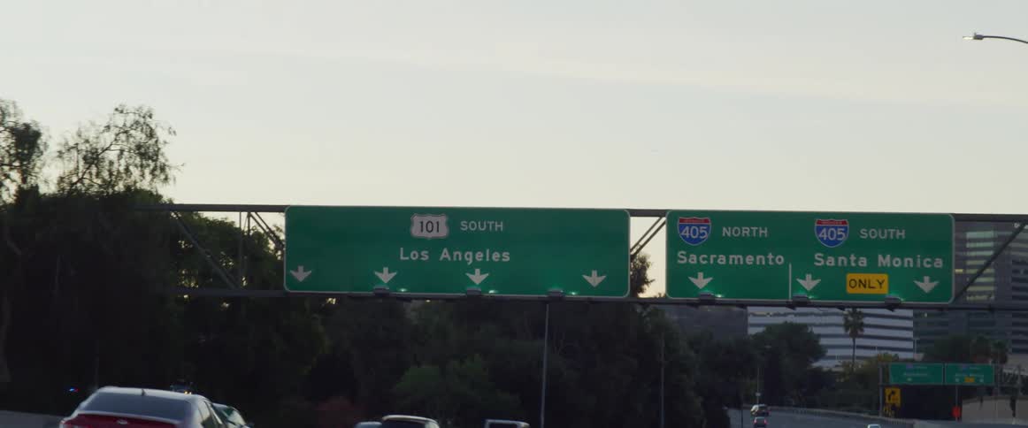 Cars driving on the freeway through los angeles at sunset