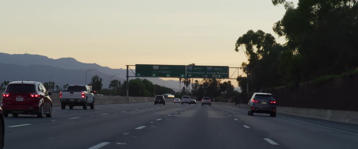 A highway with cars in calm traffic during sunset