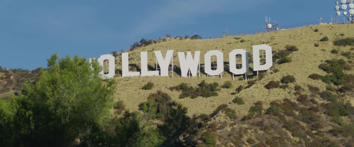 The hollywood sign on a hillside under the blue sky