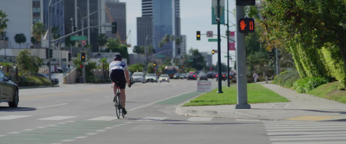 Cyclist on the streets of los angeles seen from a moving vehicle