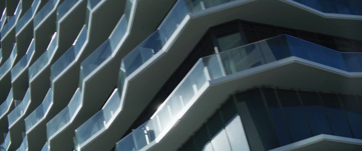Modern architectural building with multiple balcones under a blue sky