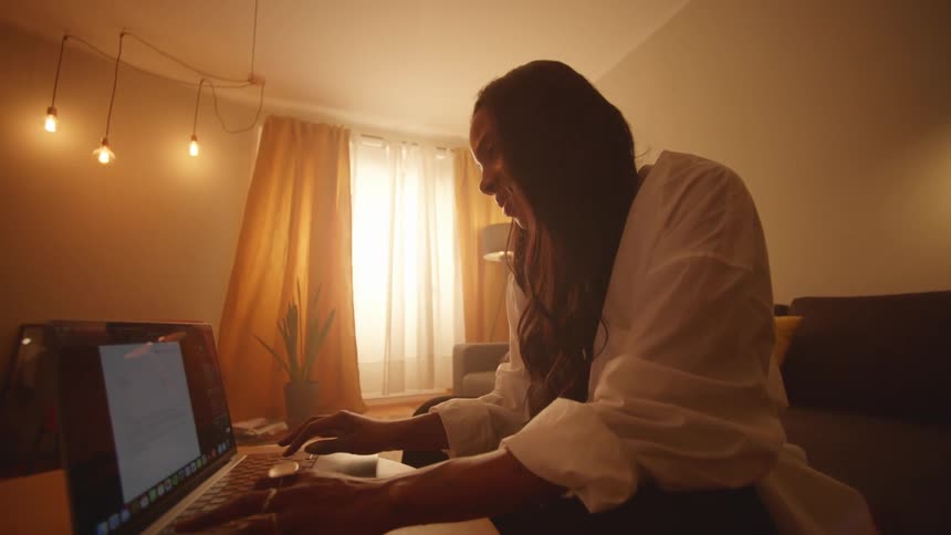 Young woman sitting in the livingroom working on a laptop