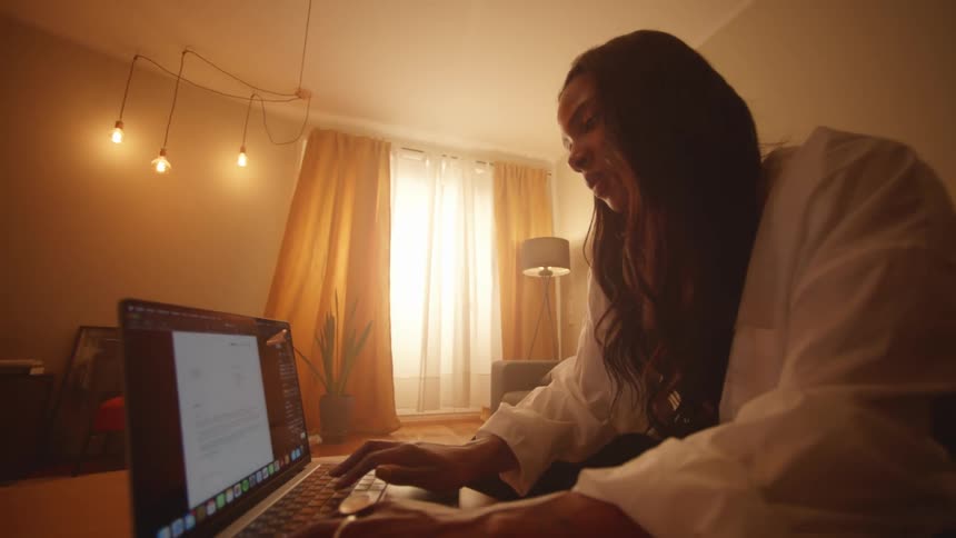 Woman sitting at home opens a laptop to start working