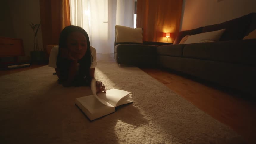 Woman reading over a rug in the living room