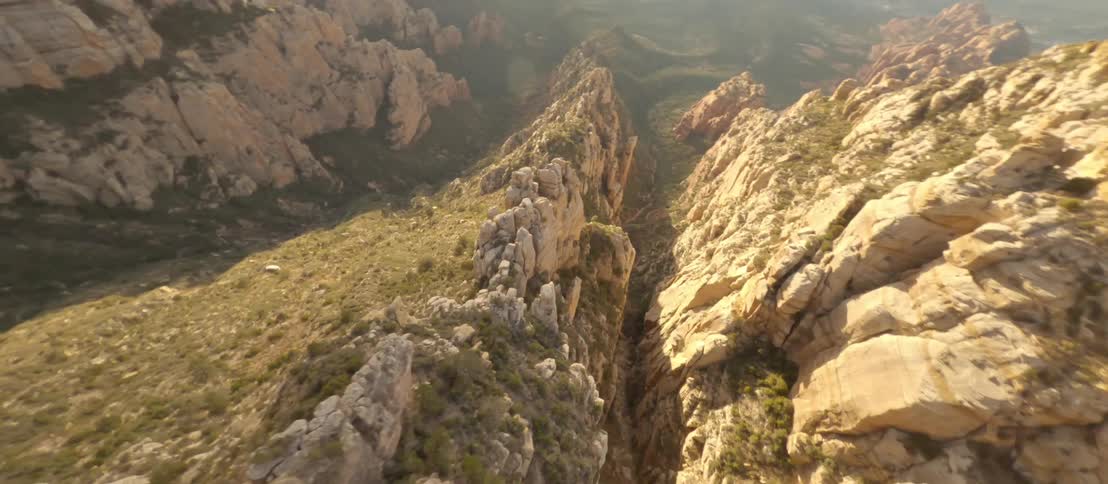 An aerial view descending from the highest part of a mountain to its base