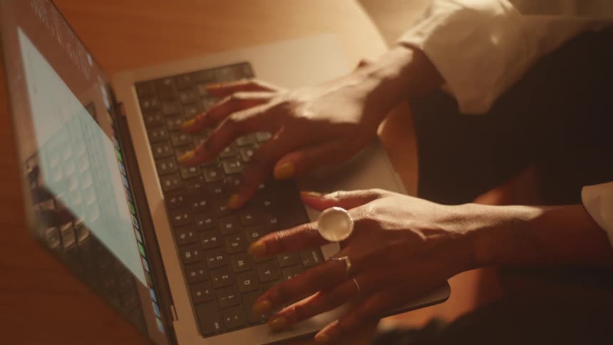 A person typing a document on a laptop
