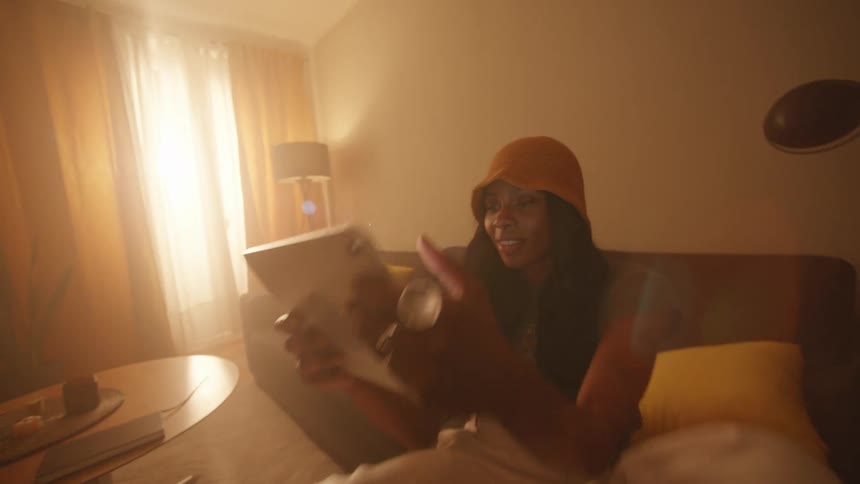 Woman sits in the couch in the living room to use a table