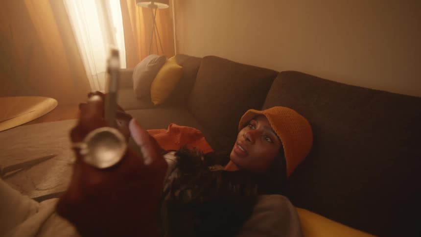 A young woman typing on a tablet in the living room