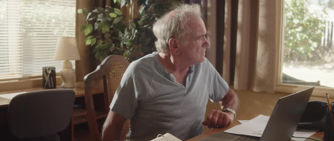 A confused man working on his computer at home