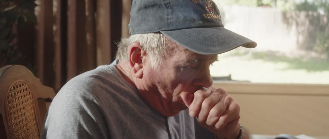 Elderly man sitting at home as a small coughing fit