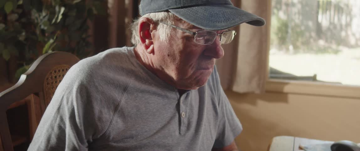 Elderly man sitting at a desk working from home