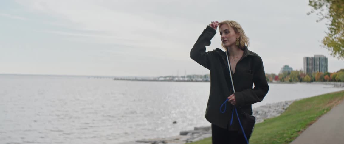 Woman walking near a lakefront on a cloudy day in autumn