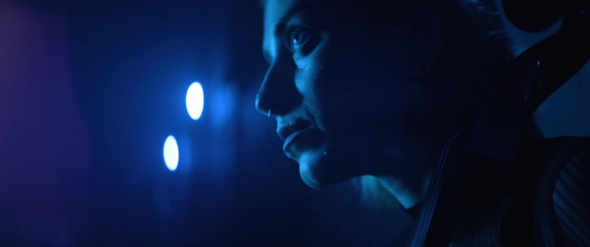 Closeup of a womans face holding a musical instrument backstage before a performance