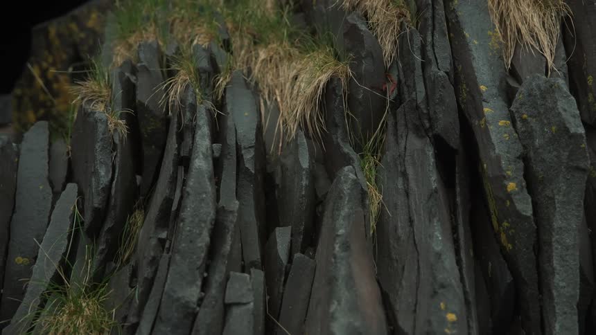 The mountain has long grass on the side