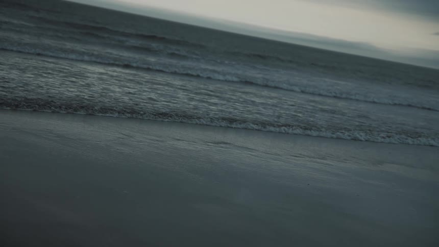Waves roll into shore and over the beach