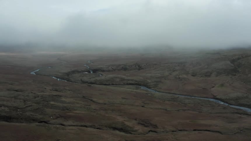 Aerial of a small stream in a plain during a cloudy day