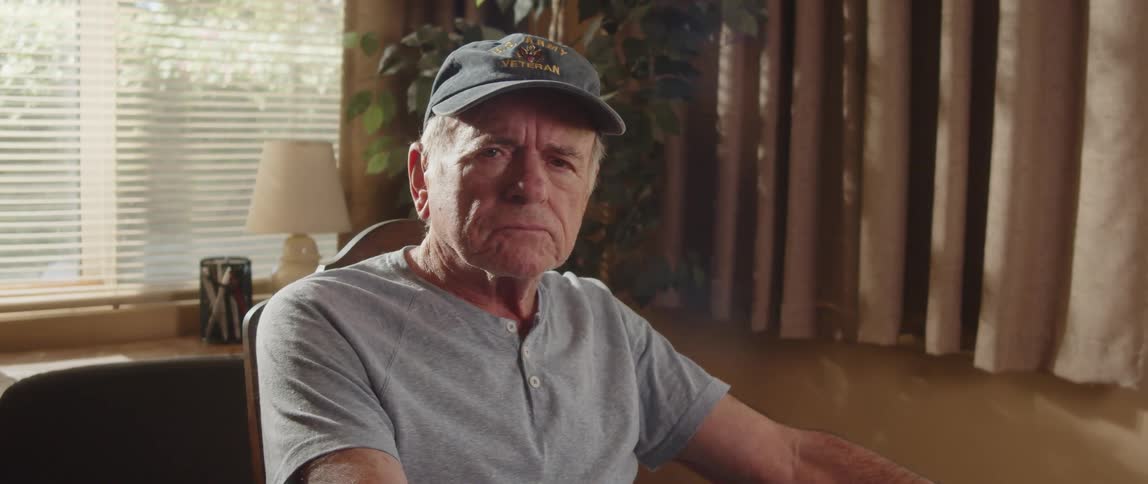 A sad old man sitting in a chair