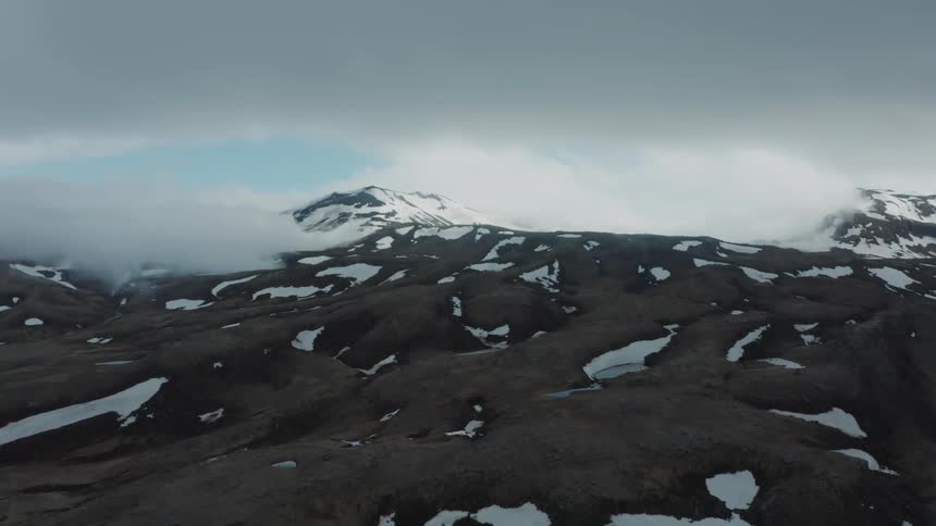 Aerial view of small lakes and snow in the mountains