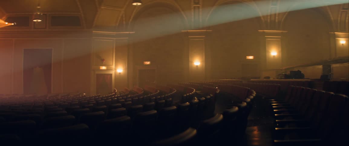 Rows of empty seats in the theater with an overhead spotlight