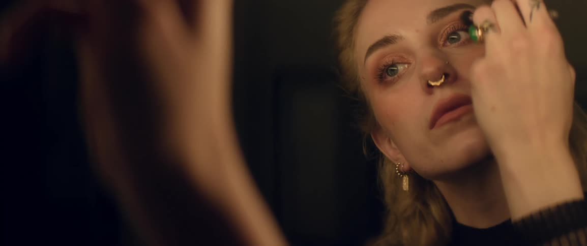 Woman applying eye makeup in front of the mirror