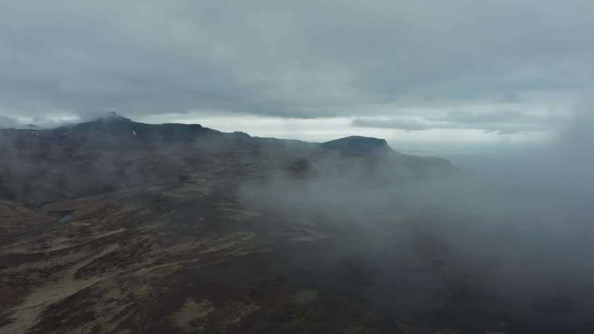 Aerial of desert landscape of plains and mountains during a cloudy day