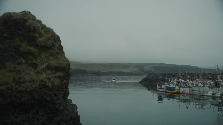 Series of boats parked on a river bank with on driving towards the bank of the river