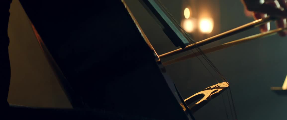 A person is playing the cello as their bow moves across the strings