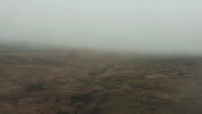 Aerial view of a river through the foggy countryside