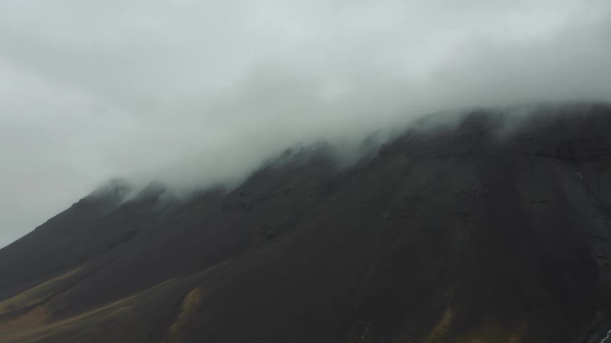 Top of a mountain covered in fog at dusk