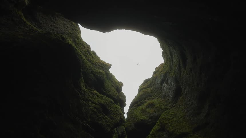 Birds fly over the cave