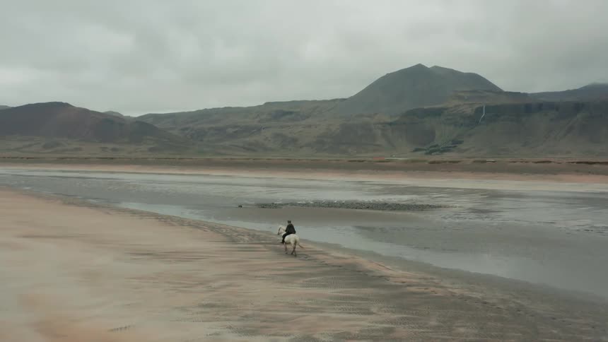 An horse rider riding beside the river