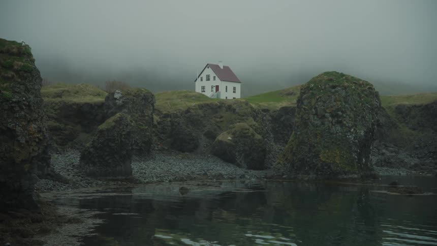 A house on the coast of a hill facing the beach