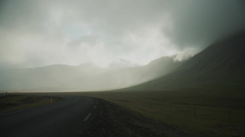 Dark clouds move over a mountain along the roadside