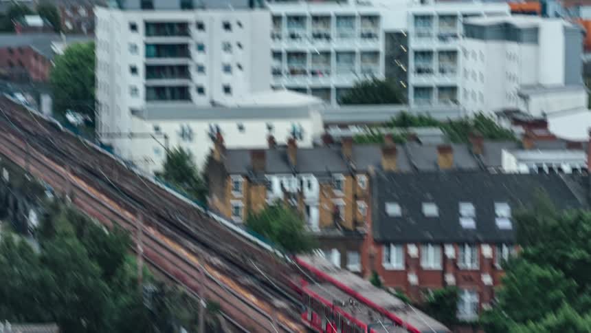 Public train passing on a bridge track amid a metropolis