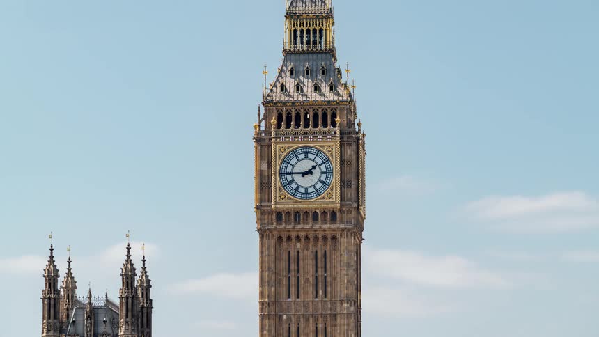 The big beg clock tower stands tall under a blue sky with few clouds