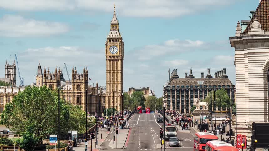 Vehicle and foot traffic pass big ben in london