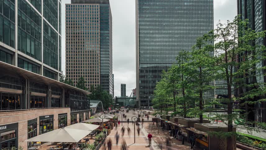 A busy urban scene with modern buildings and a pedestrian walkway