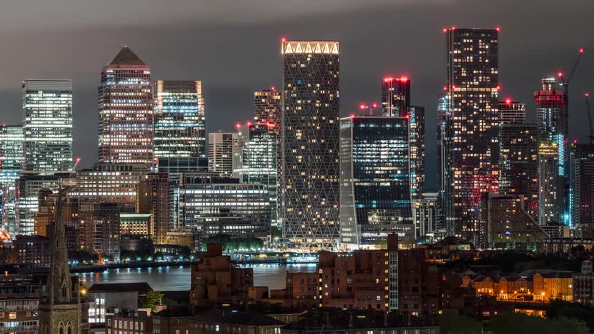 A city center with many tall buildings full of lights at night