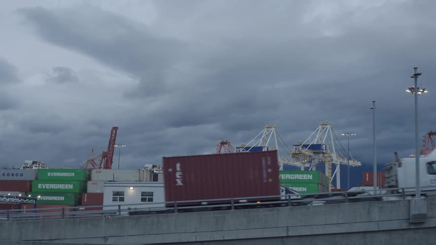 A clip of trucks transporting a cargo container