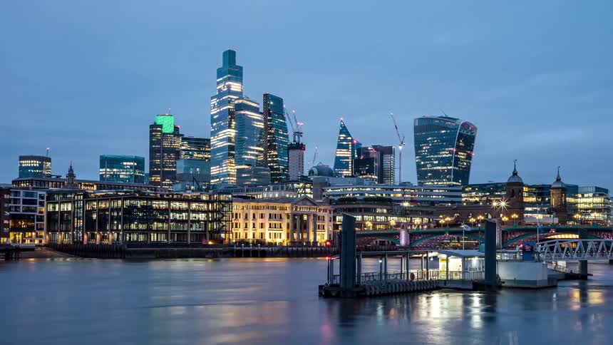 The river thames flows surrounded by modern and historical buildings