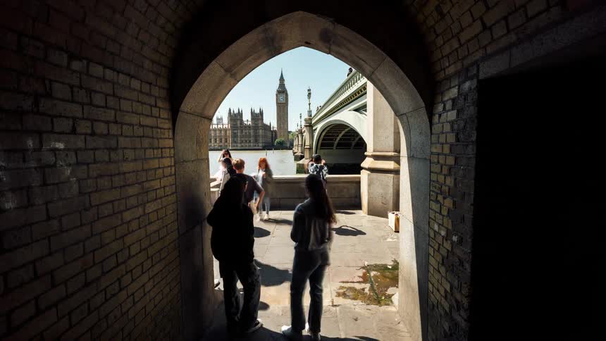 Some group o people on an allly by a bridge taking pictures
