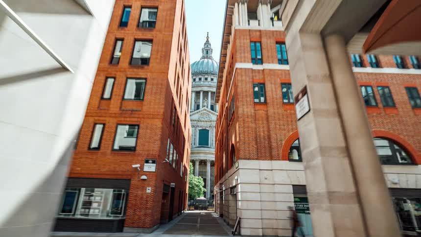 View of a corridor with a church featuring a dome in the background in daylight and in timelapse