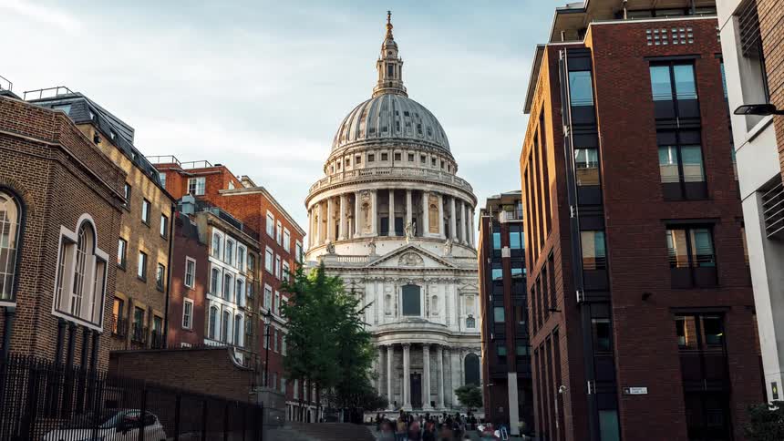 Panorama of a church in the midst of a city with people passing by outside in timelapse
