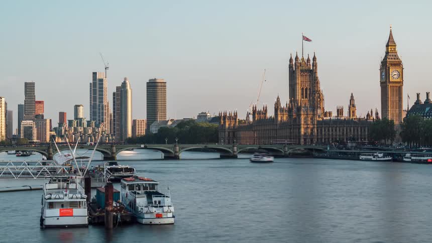 Boats travel in the river past the tall buildings