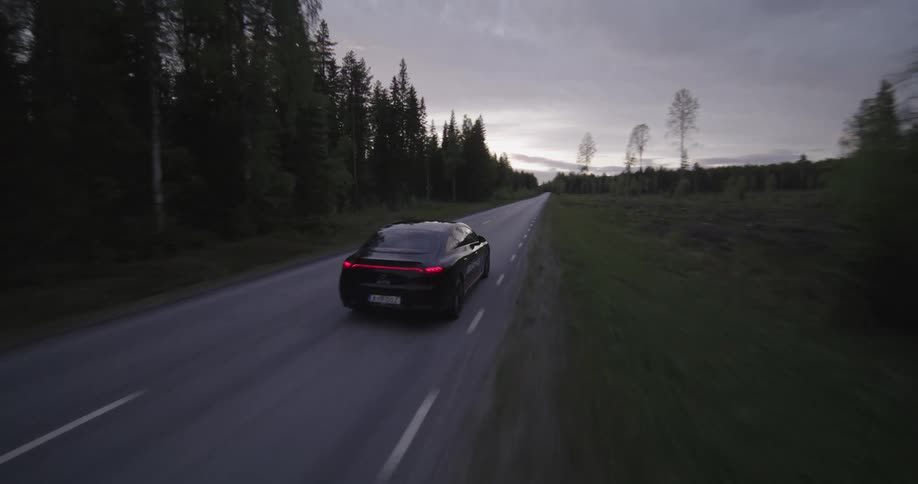 A sport car driving fast in the freeway in a rural setting