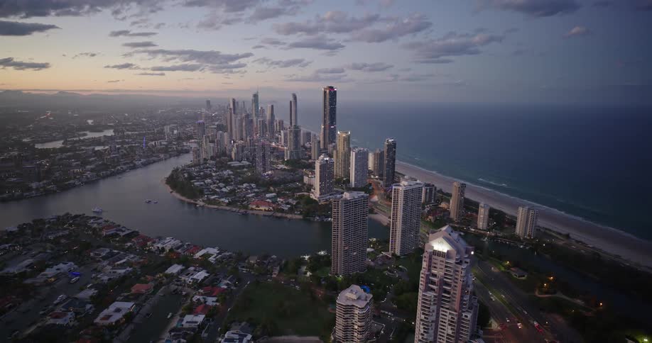Aerial panorama of a metropolis with skyscrapers by the sea under a purple dawn sky