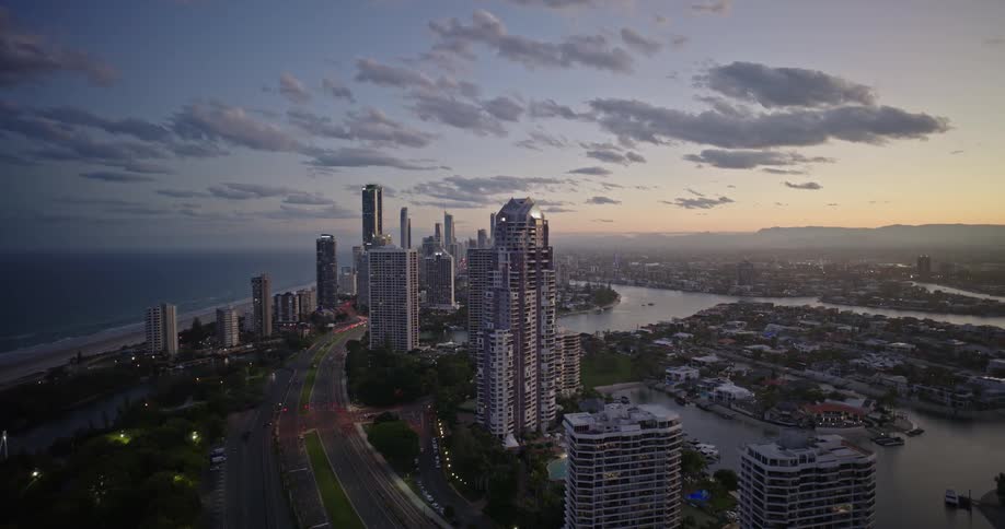 Aerial panorama of a metropolis with skyscrapers by the sea under a purple dawn sky
