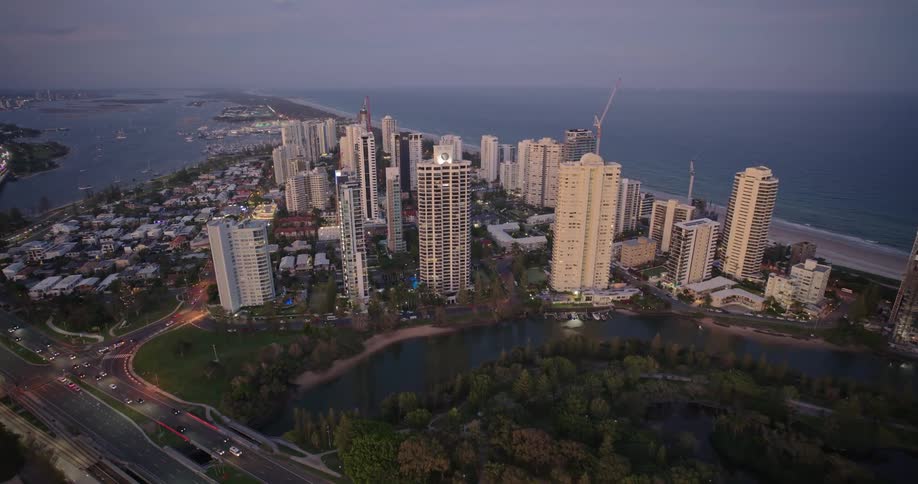 Aerial view of a city at dusk with a river and the sea behind it