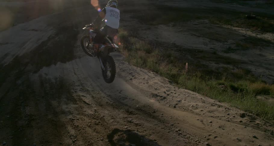 A man is jumping a dirt ramp with a motocross bike
