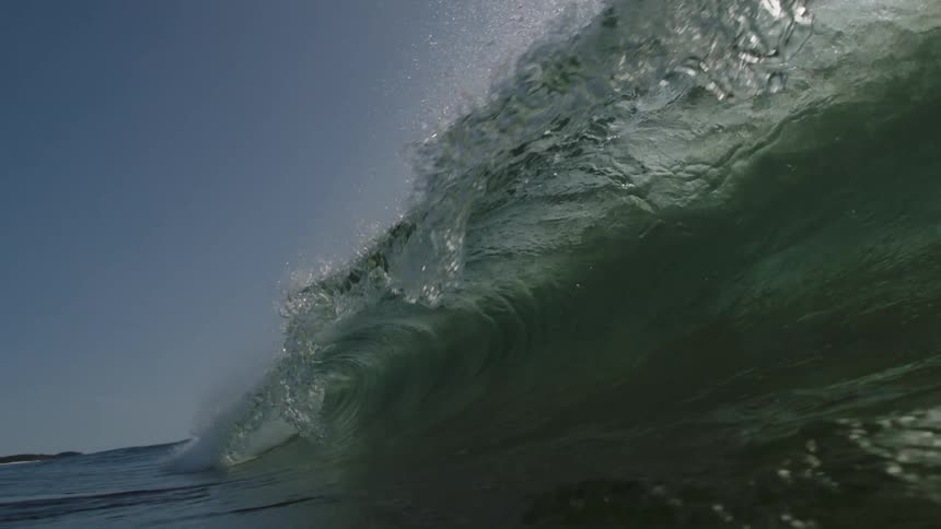 Large wave crests and collapses with shore in the distance
